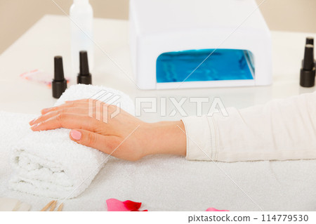 Woman hand on towel, next to manicure set 114779530