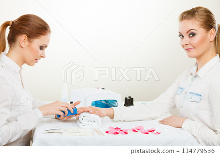 Beautician with client at beauty salon. 114779536