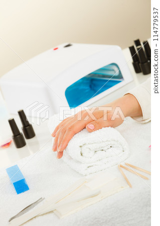 Woman hand on towel, next to manicure set 114779537