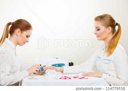 Beautician with client at beauty salon. 114779538