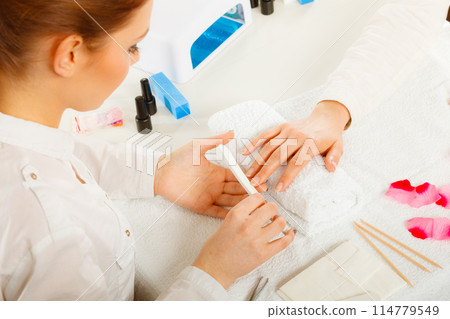 Woman getting manicure done file nails 114779549