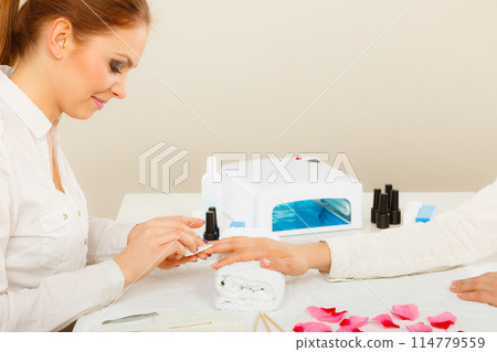 Woman making manicure using nail polish remover 114779559