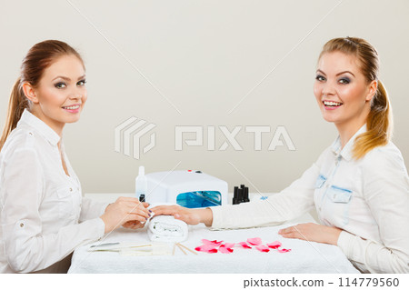 Beautician with client at beauty salon. 114779560