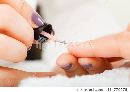 Woman in beauty salon getting manicure done. 114779576