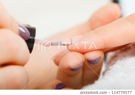 Woman in beauty salon getting manicure done. 114779577