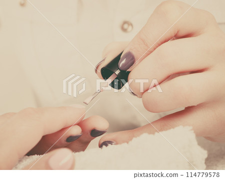 Woman in beauty salon getting manicure done. 114779578