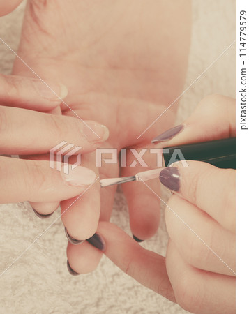 Woman in beauty salon getting manicure done. 114779579