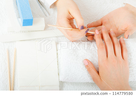 Woman in beauty salon getting manicure done. 114779580