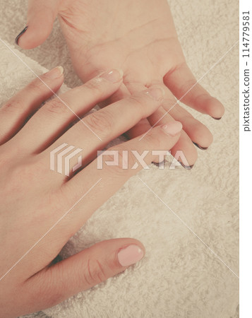 Woman hand on towel, next to manicure set 114779581