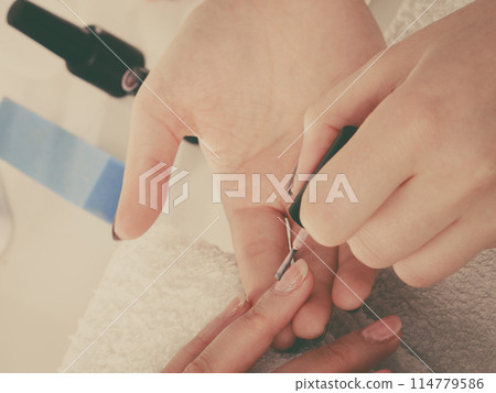 Woman in beauty salon getting manicure done. 114779586