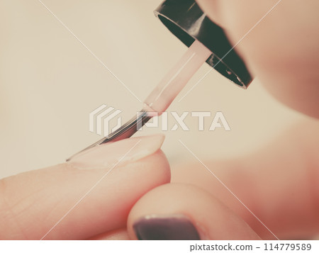 Woman in beauty salon getting manicure done. 114779589