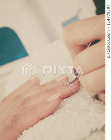Woman in beauty salon getting manicure done. 114779597