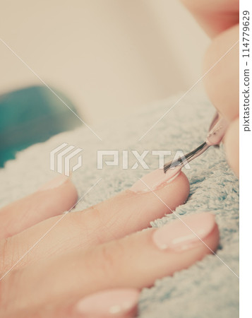 Woman in beauty salon getting manicure done. 114779629
