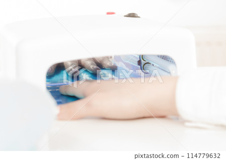 Woman hand in uv led lamp drying gel manicure 114779632