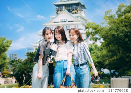 Three girls taking a selfie in front of Osaka Castle 114779658