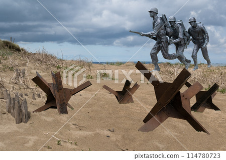 Normandy France D-Day soldiers sculptures and hedgehogs photomontage at WWII Utah Beach. Veterans Day rememberance. High quality photomontage 114780723