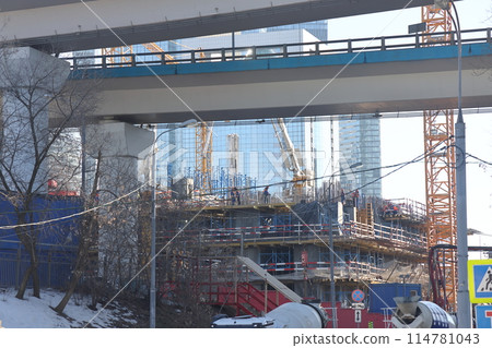 Overpasses on the background of skyscrapers. Blue sky and bright sun. 114781043