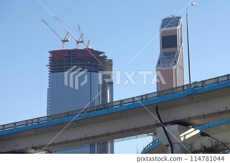 Overpasses on the background of skyscrapers. Blue sky and bright sun. Overpasses on the background of skyscrapers. Blue sky and bright sun. 114781044