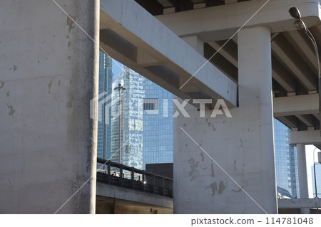 Overpasses on the background of skyscrapers. Blue sky and bright sun. 114781048