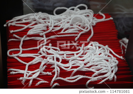 A stack of red paper bags with white rope handles. A stack of red paper bags with white rope handles. 114781081