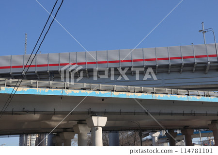 Overpasses on the background of skyscrapers. Blue sky and bright sun. Transport interchanges 114781101