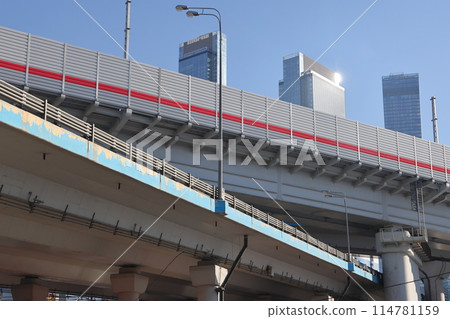 Overpasses on the background of skyscrapers. Blue sky and bright sun. Transport interchanges Overpasses on the background of skyscrapers. Blue sky and bright sun. Transport interchanges 114781159