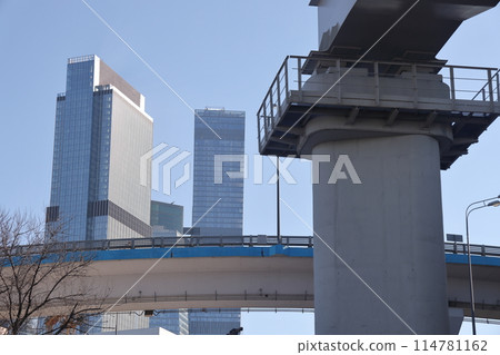 Overpasses on the background of skyscrapers. Blue sky and bright sun. Transport interchanges 114781162
