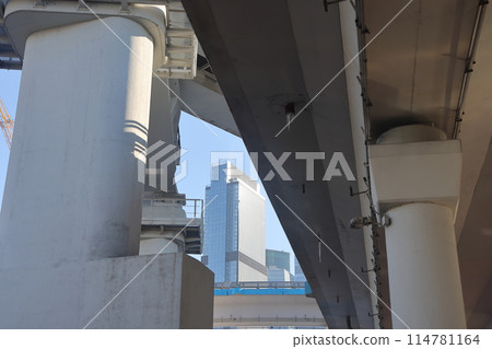 Overpasses on the background of skyscrapers. Blue sky and bright sun. Transport interchanges 114781164