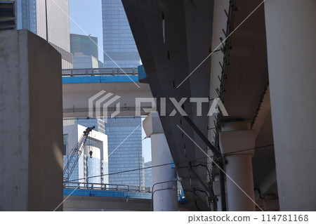 Overpasses on the background of skyscrapers. Blue sky and bright sun. Transport interchanges 114781168