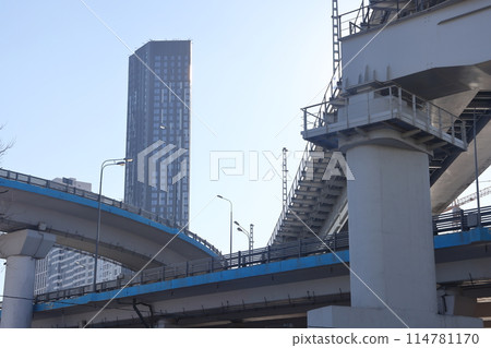 Overpasses on the background of skyscrapers. Blue sky and bright sun. Transport interchanges 114781170