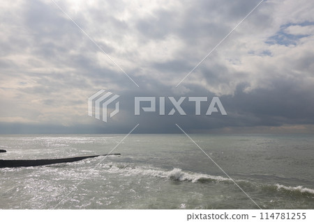 Sochi, Russia 05.07.2021. Breakwater pier summer black sea cloudy. Sochi, Russia 05.07.2021. Breakwater pier summer black sea cloudy. 114781255