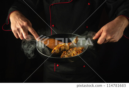 Preparing fried fish in a restaurant kitchen. Cook or fry rudd fish in a frying pan. Delicious fish dish idea 114781683