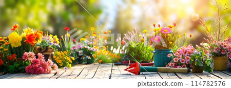 A wooden table covered with vibrant and diverse colorful flowers, along with various garden tools, set against a blurred natural background. Generative AI 114782576
