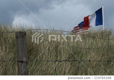 Normandy area of Utah beach. French, and USA and French Revolutionary flag are waving. Cloudy sky. High quality photo Normandy area of Utah beach. French, and USA and French Revolutionary flag are waving. Cloudy sky. High quality photo 114783108