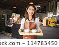 smiling waitress holding a tray of coffee 114783450