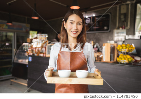 smiling waitress holding a tray of coffee smiling waitress holding a tray of coffee 114783450