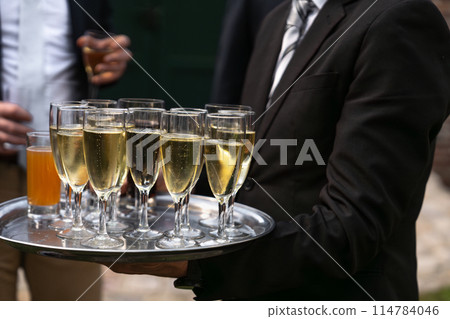 A waiter serving champagne at a wedding 114784046