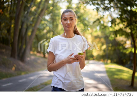 Confident female jogger listening to music in Confident female jogger listening to music in 114784723