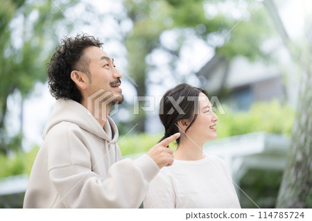 Close-up of a couple looking at the future and hopes amidst fresh greenery 114785724