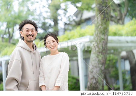 Close-up of a married couple smiling amidst fresh greenery 114785733