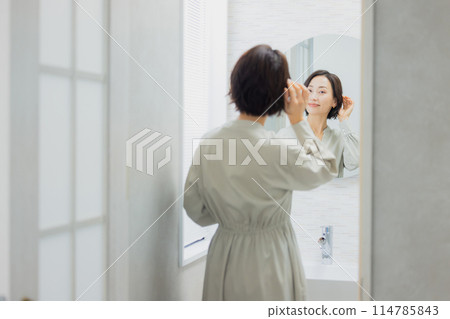 看在洗手間的婦女一個鏡子 看在洗手間的婦女一個鏡子 114785843