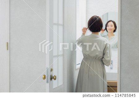 看在洗手間的婦女一個鏡子 看在洗手間的婦女一個鏡子 114785845