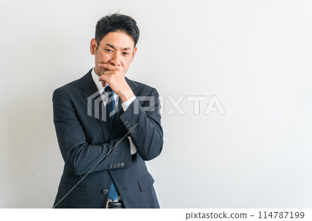 一位穿著西裝的中年亞洲商人，雙臂交叉思考（擔心，困擾，困擾，戰略家，策略，操作，考慮） 114787199