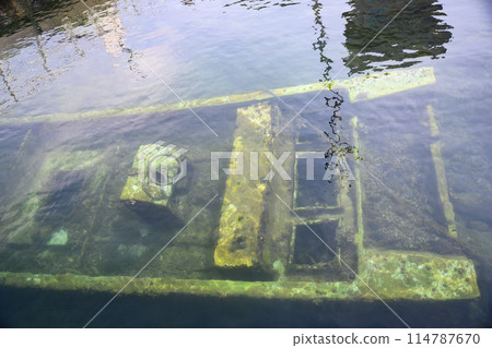 A boat sunk at a shallow depth in a sea bay A boat sunk at a shallow depth in a sea bay 114787670