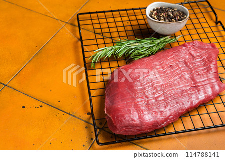 Raw flank beef meat steak ready for grilling. Orange background. Top view. Copy space Raw flank beef meat steak ready for grilling. Orange background. Top view. Copy space 114788141