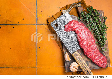 Fresh Raw Machete beef meat steak or hanging tender cut on butcher cutting board. Orange background. Top view. Copy space 114788145
