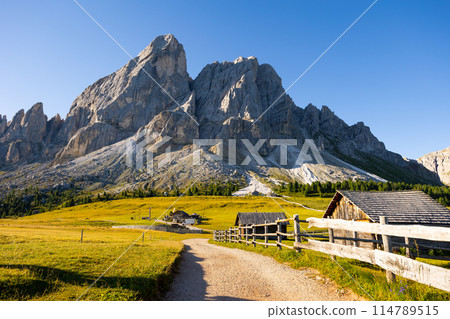 Countryside view of Dolomites mountains. Houses in mountains against Munt de Fornella, South Tyrol, Italy Countryside view of Dolomites mountains. Houses in mountains against Munt de Fornella, South Tyrol, Italy 114789515