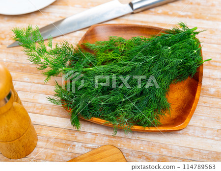 Fresh dill sprigs on kitchen table Fresh dill sprigs on kitchen table 114789563