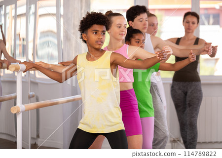 Teenage boy practicing plie position of ballet during choreography classes 114789822
