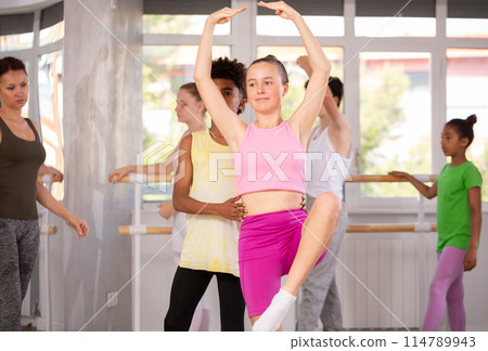 Teenage girl practicing ballet moves in pair with African American boy 114789943
